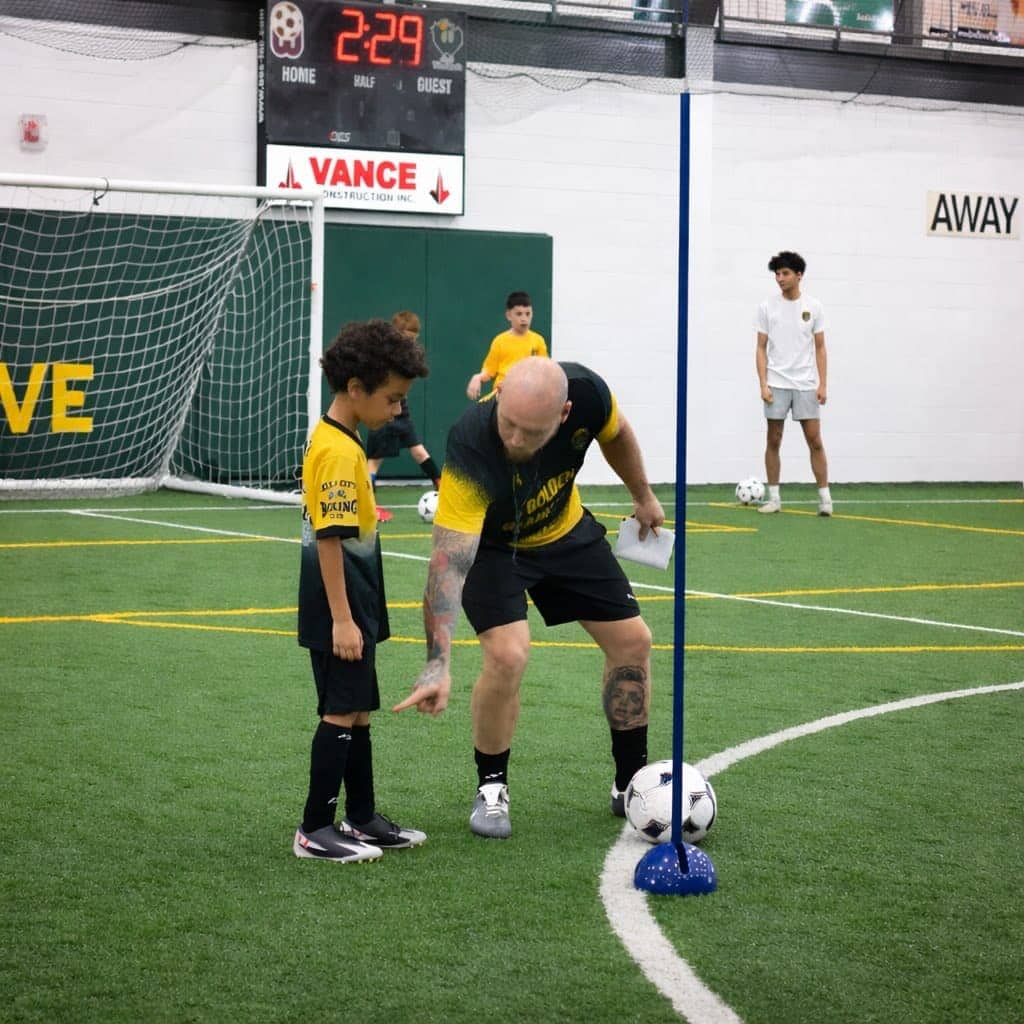 Golden Gladiators soccer training session at Woodstock FC indoor turf with players in gold and black kit