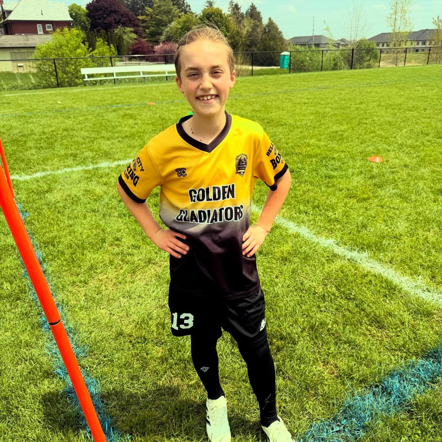 Girl in Golden Gladiators kit on a sunny training field